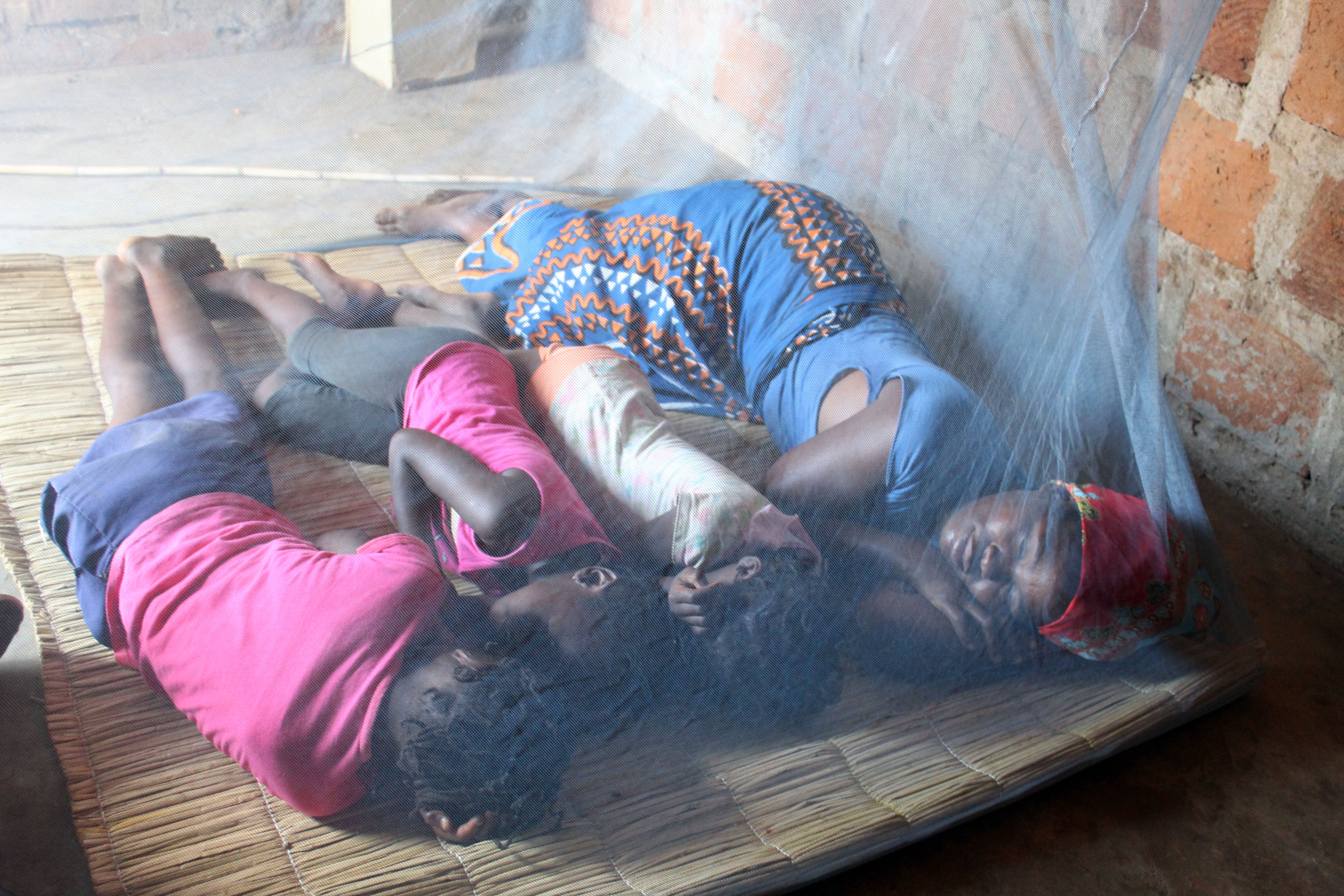 African people sleeping in mosquito net